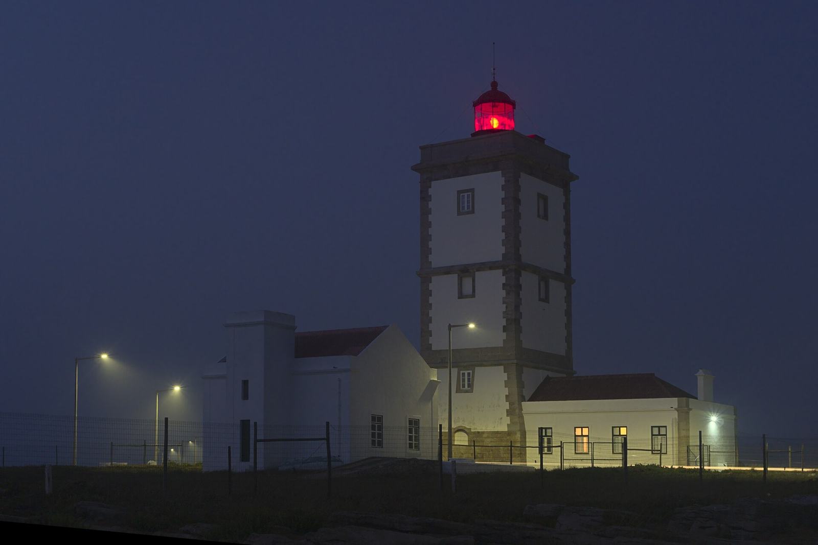 Lighthouse and keeper's buildings at night in mist