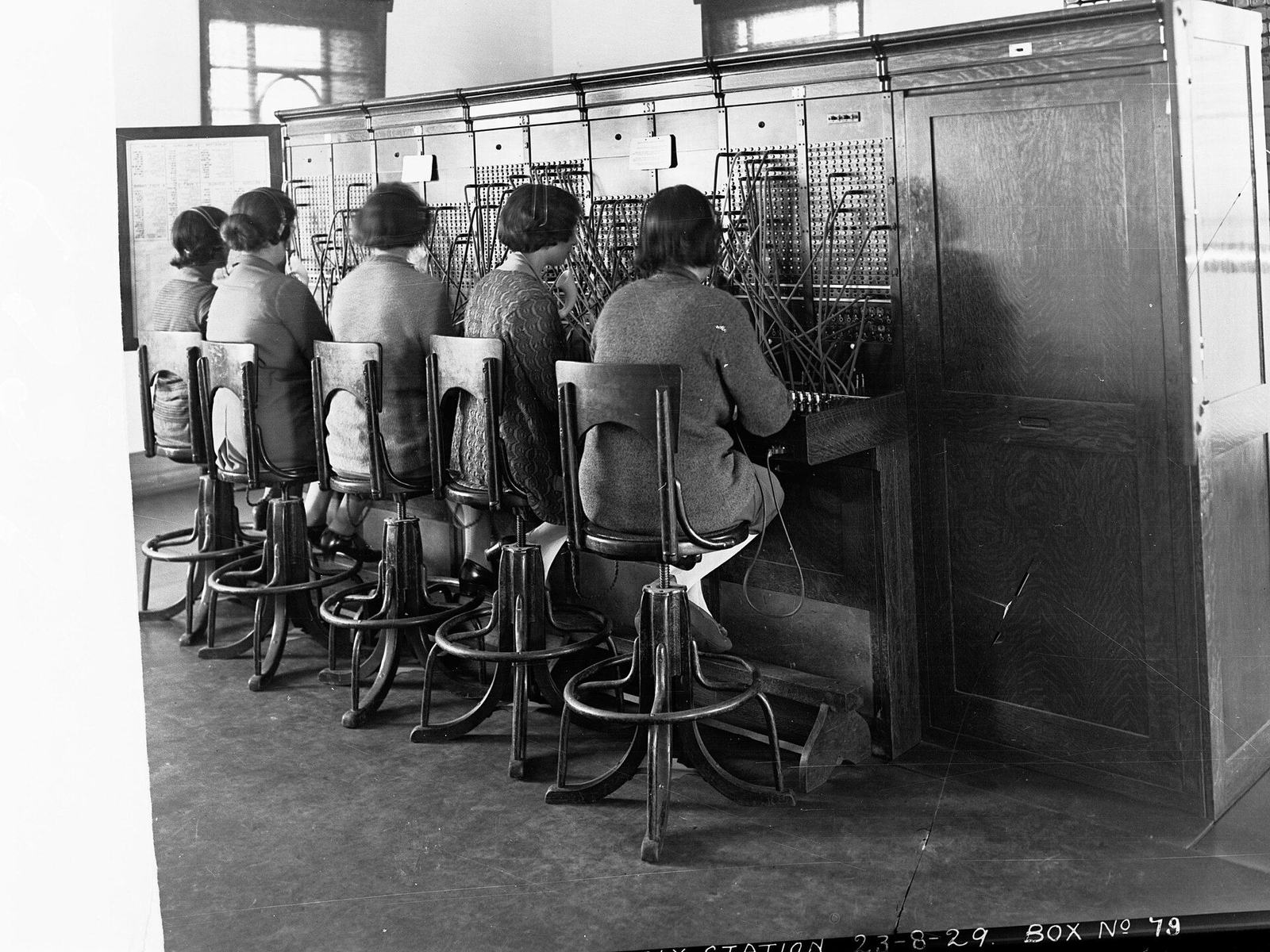 Row of operators at a manual telephone switchboard