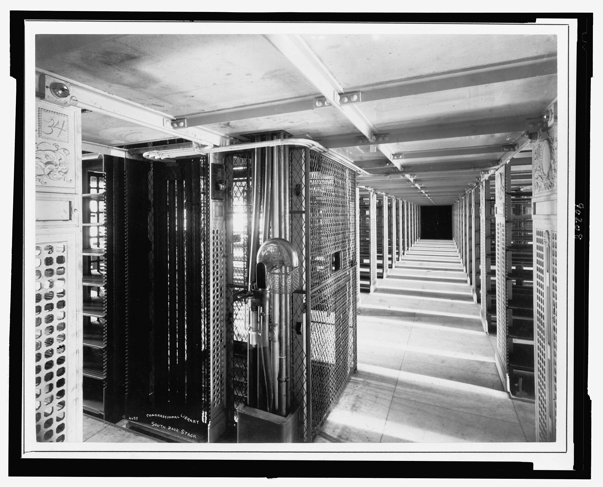 Long rows of metal book stacks in the Library of Congress, with a narrow walkway between them