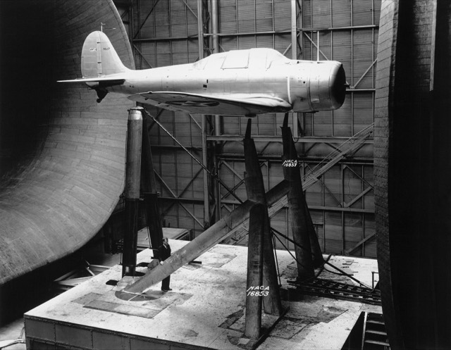 A model aircraft mounted on a stand inside a NACA wind tunnel in 1939, ready for testing