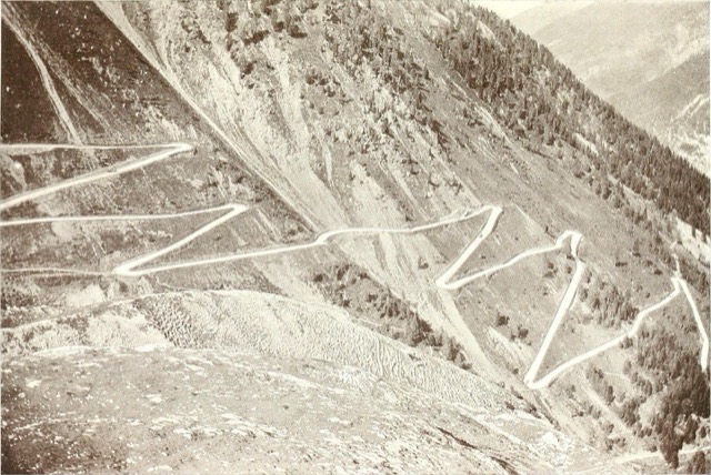 A mountain road climbing a steep valley side in a long series of hairpin bends, photographed in 1908