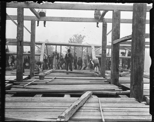 A group of men raising the timber frame of a barn in about 1900